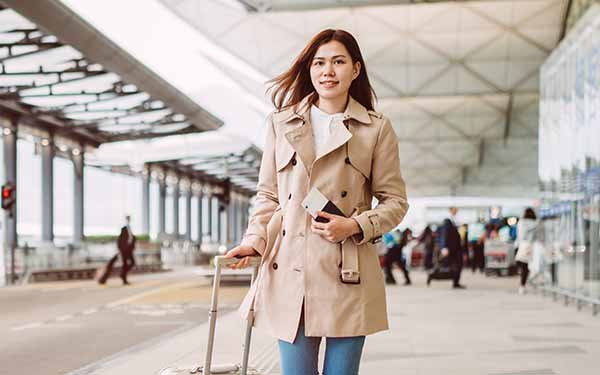 Woman walking through airport holding passport